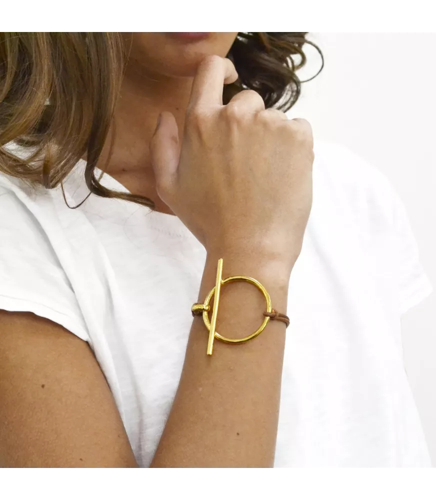 Pulsera Orígenes Slim CXC, en metal bañado en oro, con cuero liso.